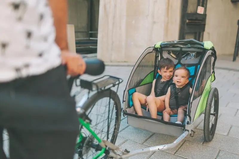 kids in a trailer towed by a bicycle