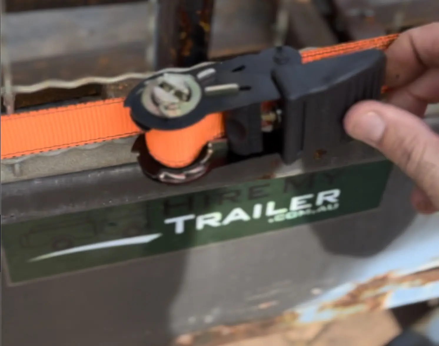 Image of a trailer tie down strap being tightened